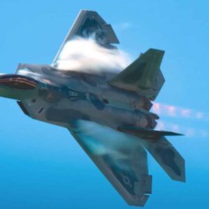 Military fighter jet flying inverted with a bright afterburner flame against a clear blue sky.
